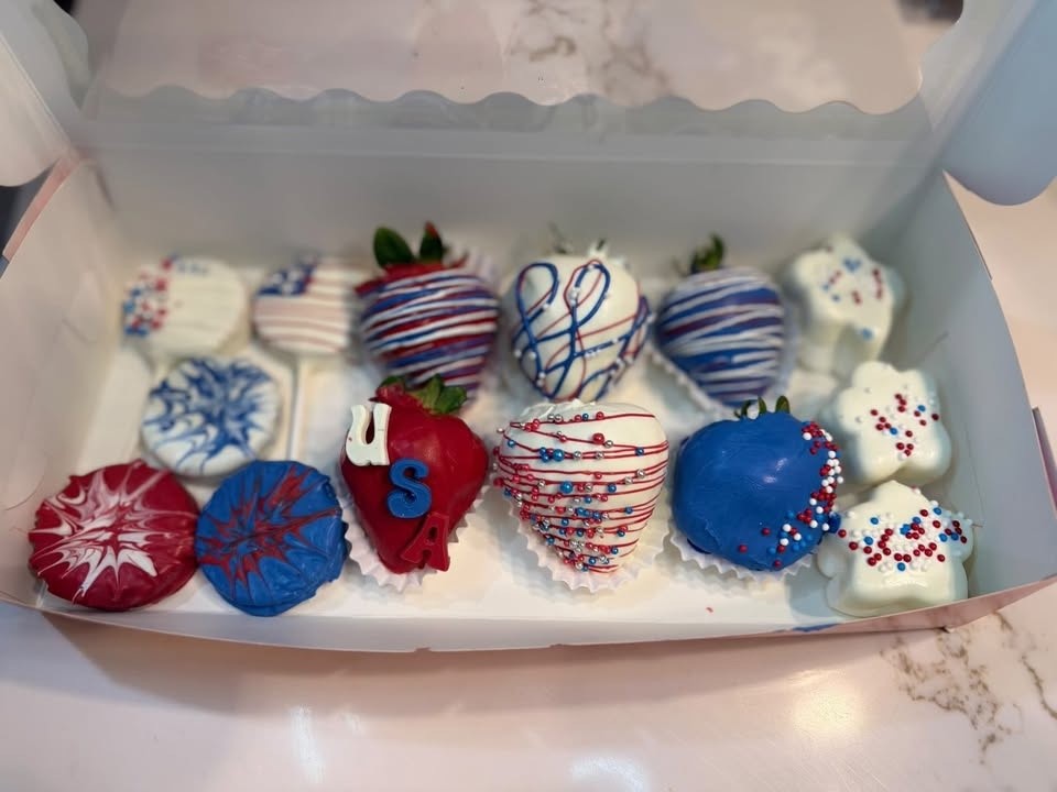 Red, white, and blue dipped strawberries and Oreos with stars in a patriotic box.