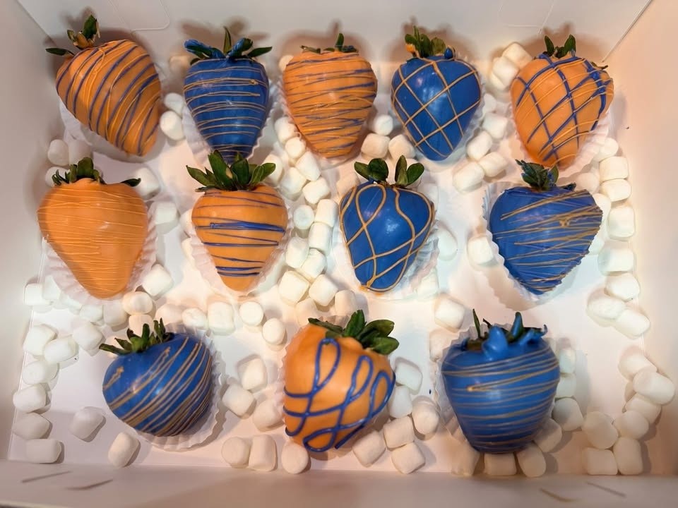 Blue and orange dipped strawberries drizzled in team colors among mini marshmallows.