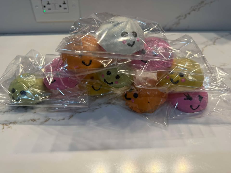 Individually wrapped smiley-face cake pops and treats in pastel wrappers.