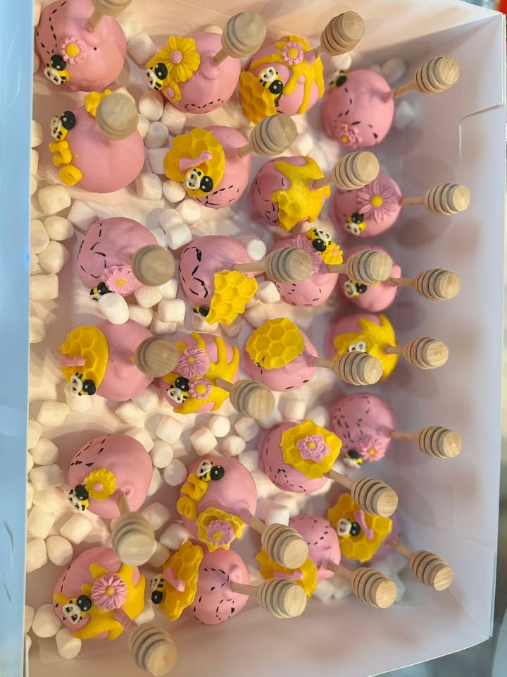 Pastel dipped strawberries and cake pops decorated with little character faces.