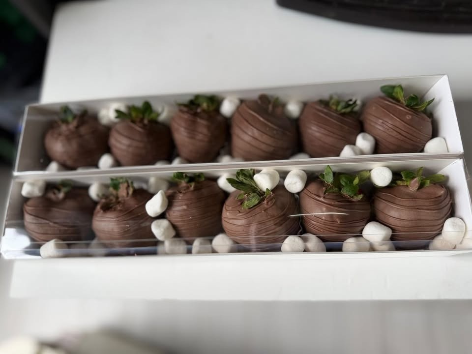 Two boxes of milk-chocolate-dipped strawberries with fine drizzle, tucked among mini marshmallows.